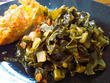 spicy collards with yellow potatoes in the background