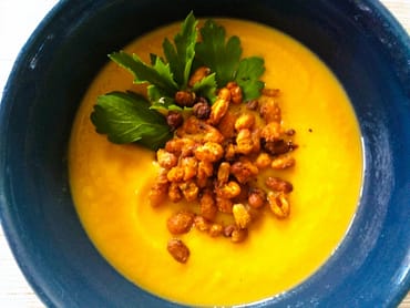 yellow soup with roasted white beans and green parsley