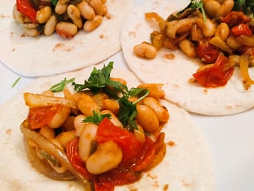 3 white bean tacos flour tortillas with sauteed onions, tomatoes and mushrooms, plus chopped cilantro