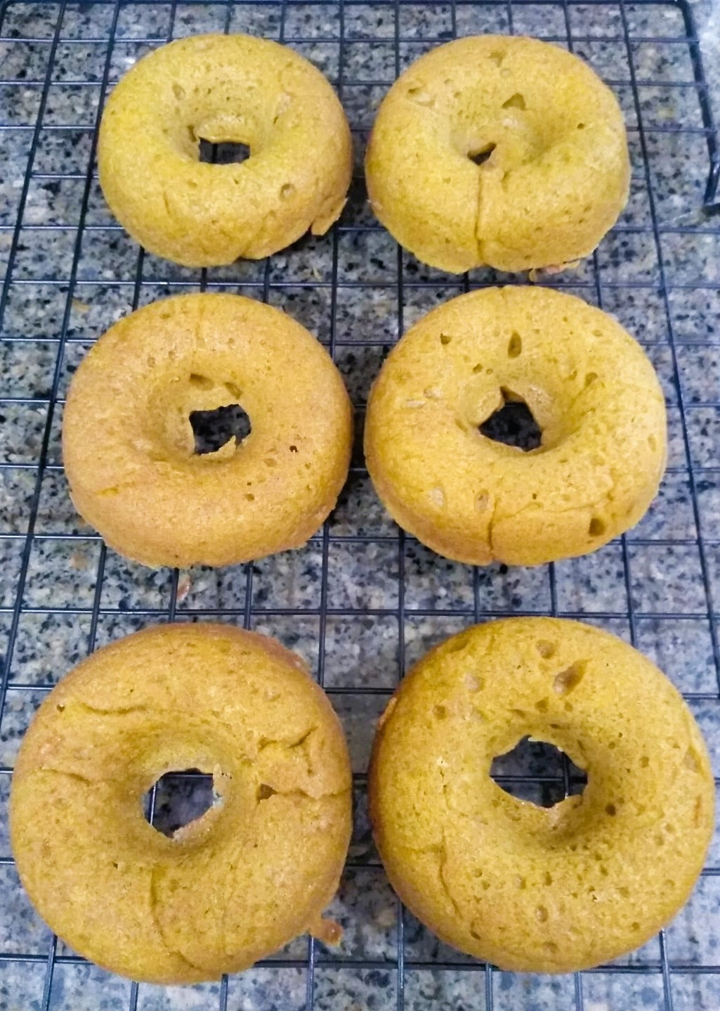 fresh baked pumpkin spice doughnuts on cooling rack