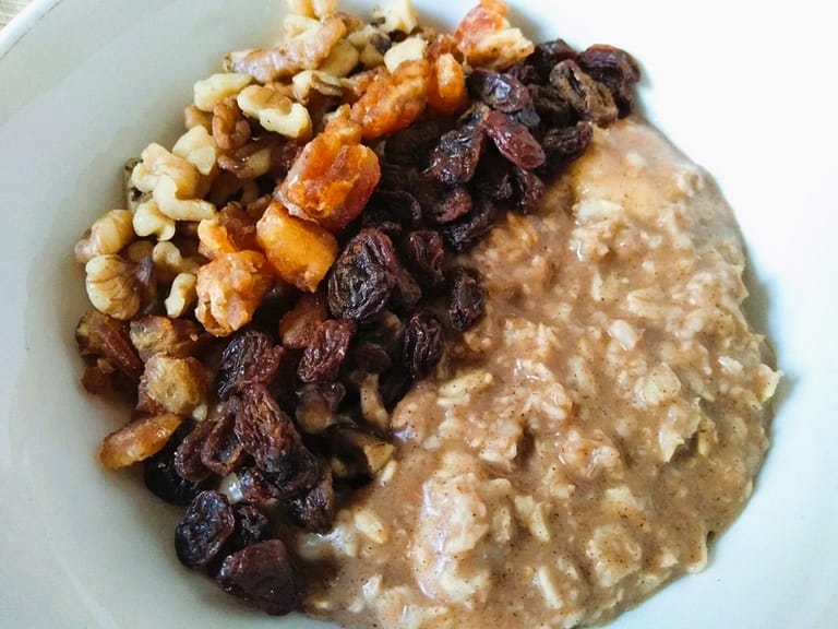 oatmeal garnished with raisins, dates, and walnuts