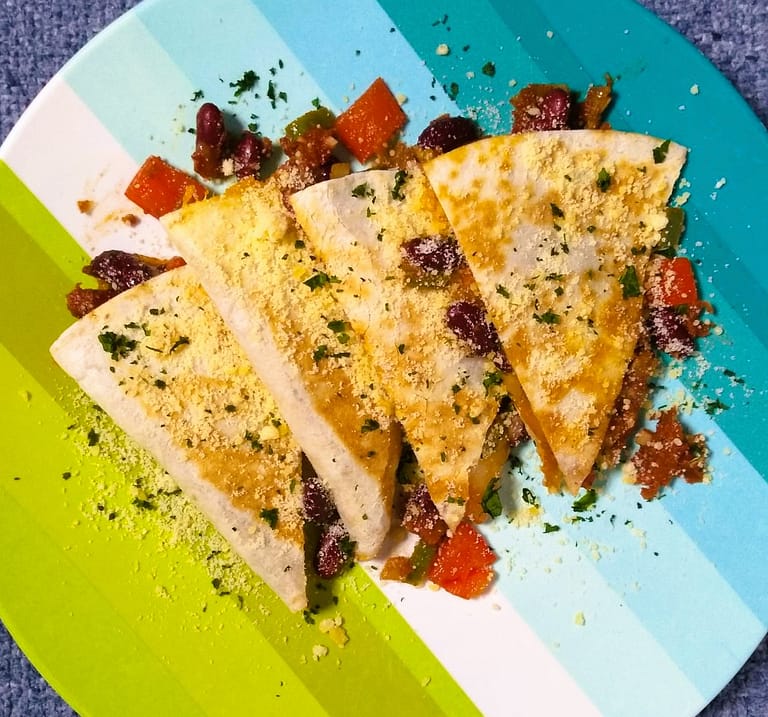 4 quesadilla slices pointing down on blue and green plate